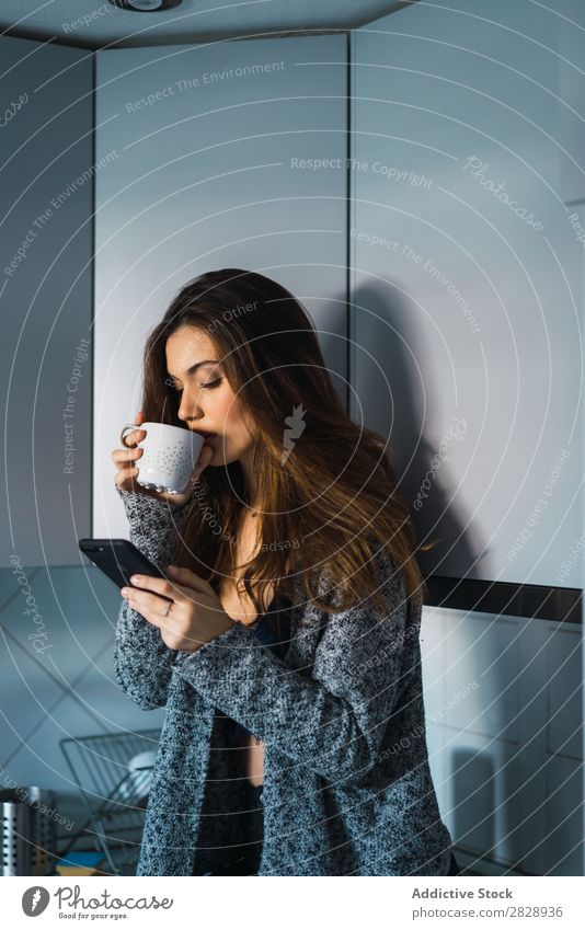 Schönes Modell mit Tasse Kaffee und Smartphone Frau heimwärts Kuscheln träumen Menschliches Gesicht Körperhaltung besinnlich Lifestyle Haus lässig romantisch