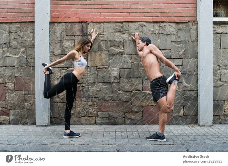 Ein Paar, das sich auf der Straße ausdehnt. Sportler strecken Stadt Fitness Sportbekleidung Training sportlich Großstadt Gesundheit stark Aktion Flexibilität