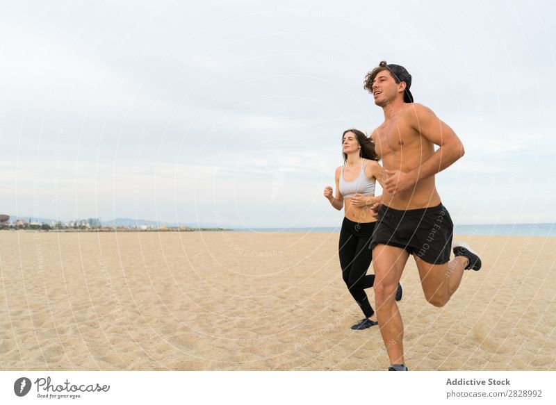 Zwei Sportler beim Laufen am Strand Paar rennen Mensch sportlich Training Küste Aktion Joggen Fitness Läufer Zusammensein Geschwindigkeit Außenaufnahme Bewegung