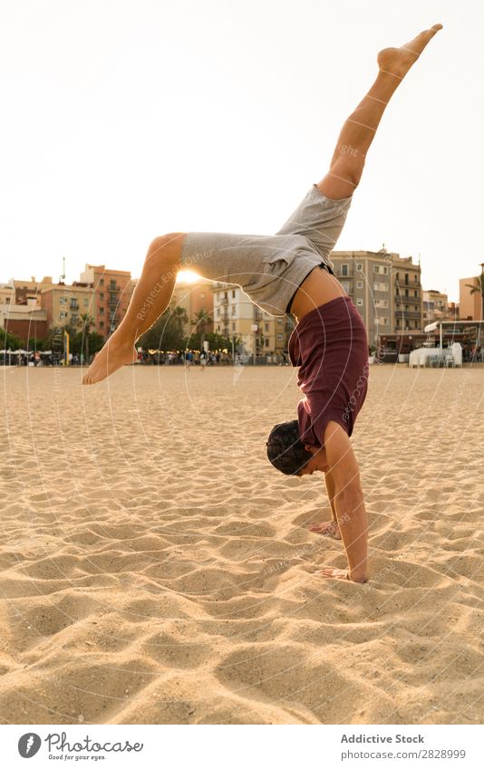 Mann im Handstand am Strand Sport üben Fitness Freiheit stehen Gleichgewicht Pose Kraft positive Seite Energie Athlet lässig Sonnenuntergang Training muskulös