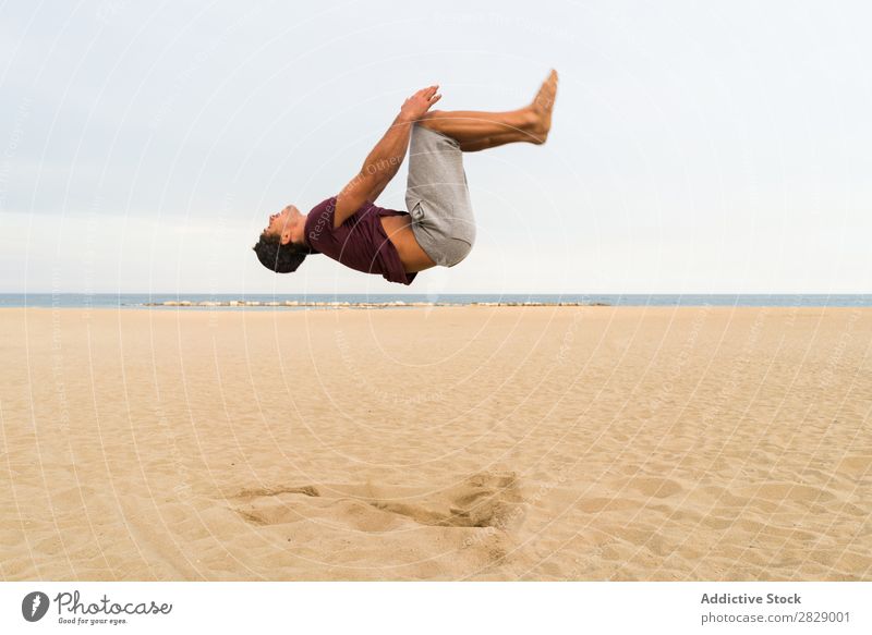 Seitenansicht des Mannes im Sprung Strand sportlich Flip springen Sport üben in Bewegung Fitness Freiheit Gleichgewicht Pose Kraft Energie Athlet lässig
