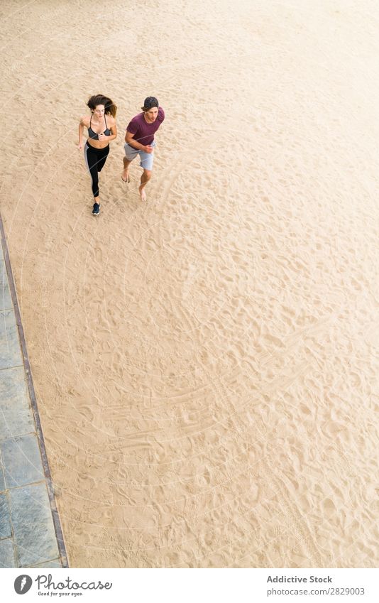 Paar, das am Strand läuft. Mensch sportlich rennen Training Aktion Joggen Fitness Küste Läufer Zusammensein Geschwindigkeit Außenaufnahme Wellness Sand Bewegung