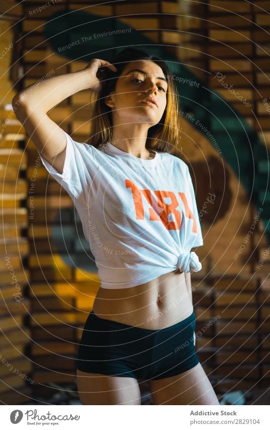 Attraktive Frau in Freizeitkleidung Verlassen Körperhaltung genießen Blick in die Kamera hübsch Jugendliche berühren Behaarung Kopf lässig T-Shirt verführerisch