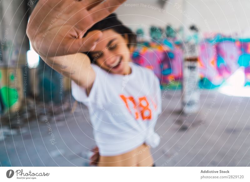 Lächelnde Frau in verlassenem Raum mit Graffiti heiter Körperhaltung Glück Jugendliche schäbig mehrfarbig hübsch lässig Verlassen Gebäude Erholung Porträt schön