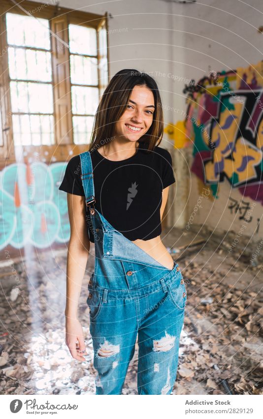 Frau, die in einem verlassenen Gebäude posiert. Verlassen Lächeln heiter Körperhaltung Graffiti attraktiv genießen Behaarung Kulisse Jugendliche Porträt schön