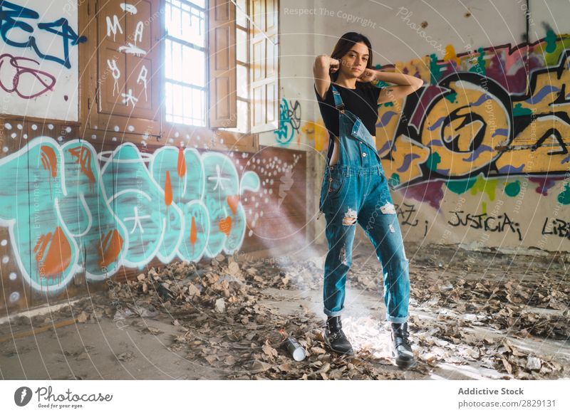 Frau setzt Haare in verlassenem Gebäude Verlassen Lächeln heiter Körperhaltung Blick in die Kamera Graffiti attraktiv genießen Behaarung Kulisse Jugendliche