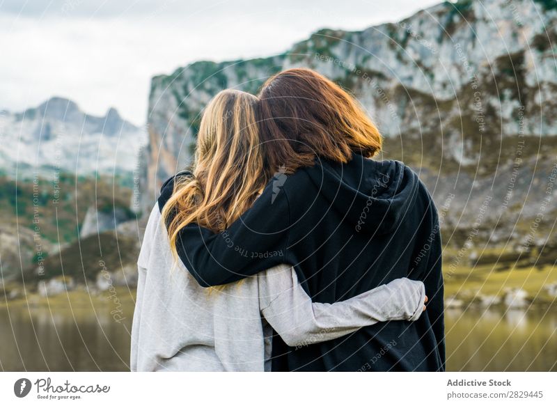Frauen am See stehend Wiese umarmend Zusammensein Freundschaft Erholung Berge u. Gebirge Natur Feld Mädchen Gras schön Jugendliche grün Frühling Mensch