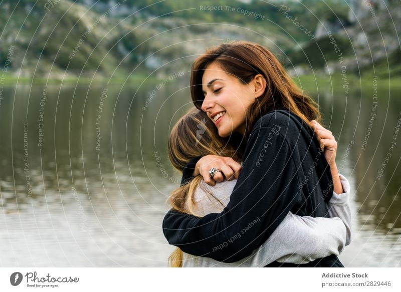 Mädchen umarmen sich am See Frau Wiese umarmend stehen Zusammensein Freundschaft Erholung Berge u. Gebirge Natur Feld Gras schön Jugendliche grün Frühling