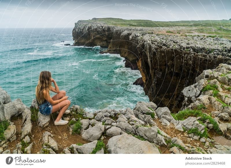 Frau, die auf einer Klippe sitzt. Meer sitzen schön Felsen Sommer Natur Ferien & Urlaub & Reisen Wasser Landschaft Jugendliche blau Lifestyle Freiheit wandern