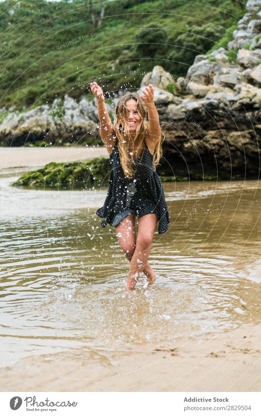 Fröhliches Mädchen, das im Wasser spielt. Frau Strand Spaß haben Geplätscher Natur Fröhlichkeit heiter Ferien & Urlaub & Reisen Sommer Felsen tropisch Spielen
