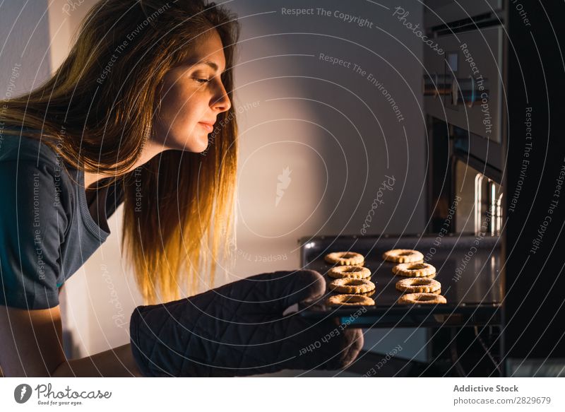 Frau, die Kekse im Ofen macht Herd & Backofen Plätzchen backen Vorbereitung Überprüfung Blechschale frisch Tablett machen Konfekt Wohnung Küche Bäckerei