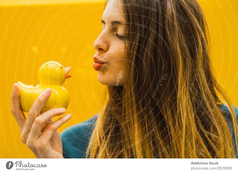 Charmante Frau mit Gummi-Ente Zufriedenheit Geben Gummiente Beautyfotografie ausdehnen unschuldig heiter Spielen hell Freiheit anbieten Menschliches Gesicht