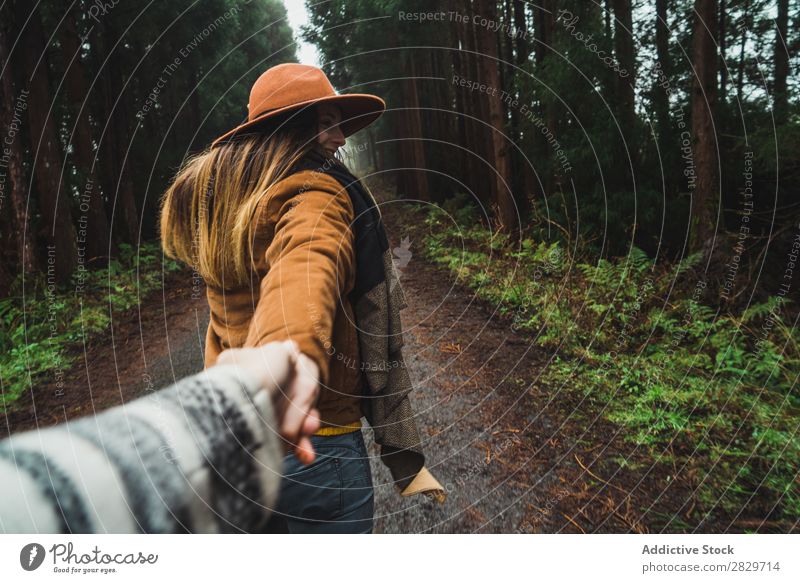 Frau hält Hand des Fotografen im Wald mir folgen romantisch Zusammensein Händchenhalten Straße verzaubert Wildnis üppig (Wuchs) Pflanze heiter führend Jacke