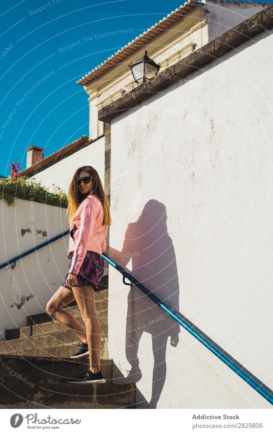Junge hübsche Frau auf der Treppe Stil Straße Sonnenbrille Freitreppe Sonnenstrahlen Außenaufnahme Mode schön Jugendliche Porträt attraktiv Großstadt Lifestyle