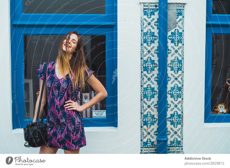 Lächelnde Frau, die auf der Straße posiert. hübsch Stil Augen geschlossen Körperhaltung Fenster Außenaufnahme Mode schön Jugendliche Porträt attraktiv Großstadt