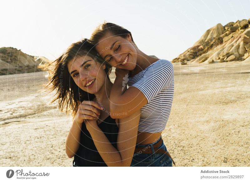 Frauen, die in sandigen Hügeln posieren. Körperhaltung Natur hübsch Augen geschlossen Lächeln heiter Glück Jugendliche schön natürlich Beautyfotografie Porträt