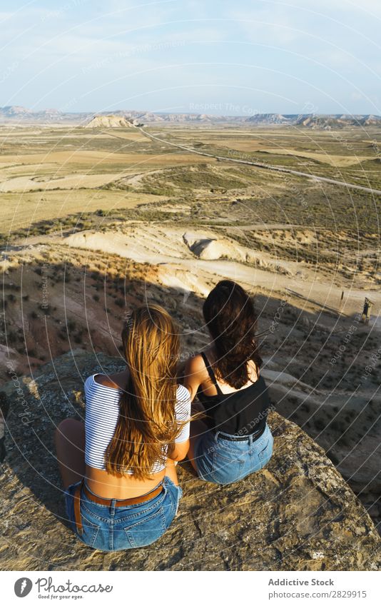 Aufgeregte Frauen, die auf einer Klippe liegen. Erholung Ferien & Urlaub & Reisen Abenteuer Felsen Berge u. Gebirge Tourist Freundschaft Zusammensein Lächeln
