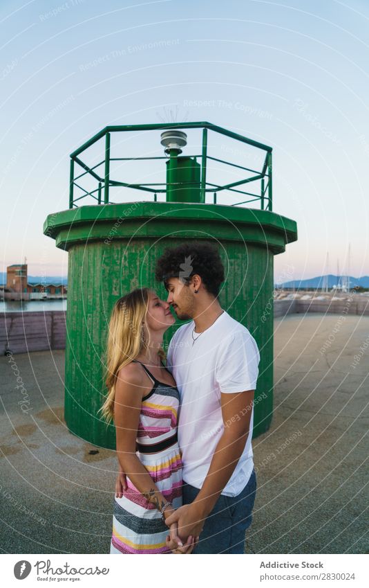 Liebenswertes Paar, das im Dock posiert. romantisch liebevoll Küssen Körperhaltung Flitterwochen Küste Romantik Zusammensein Jugendliche umarmend Erholung
