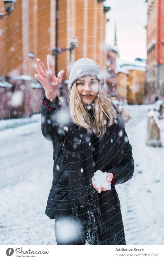 Frau, die Schnee aufwirft. Stil Straße Werfen fallend Freude modisch genießen Jugendliche hübsch Winter kalt Coolness Mode warme Kleidung Großstadt Model schön
