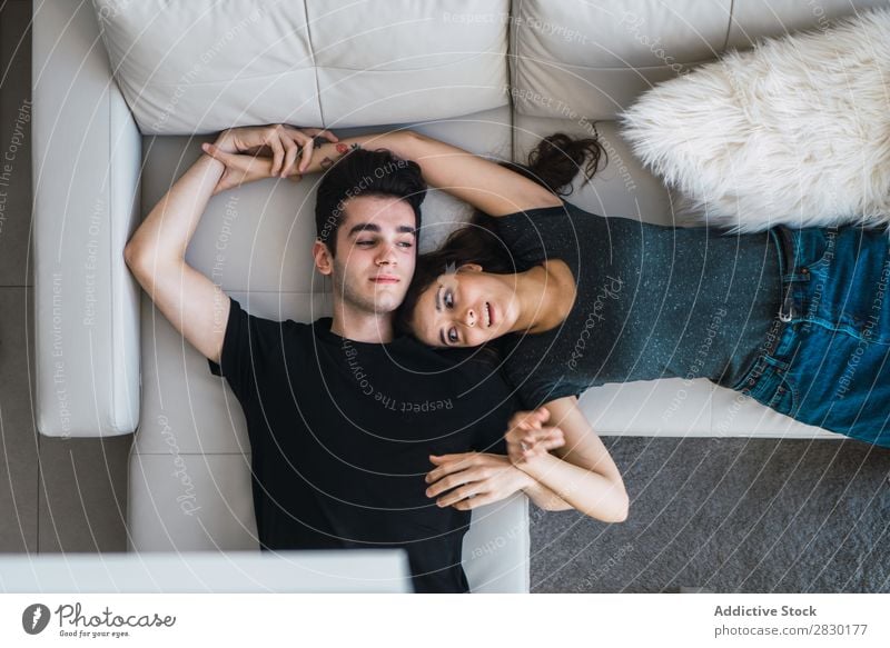 Paar auf der Couch liegend heimwärts Zusammensein umarmend Sofa Liege gemütlich Mensch Glück Liebe Haus Mann Frau Lifestyle 2 Jugendliche Erwachsene Wohnung