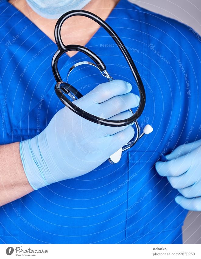 Arzt in blauer Uniform, der ein Stethoskop hält. Behandlung Krankenpflege Krankheit Medikament Arbeit & Erwerbstätigkeit Beruf Krankenhaus Werkzeug Mensch Mann