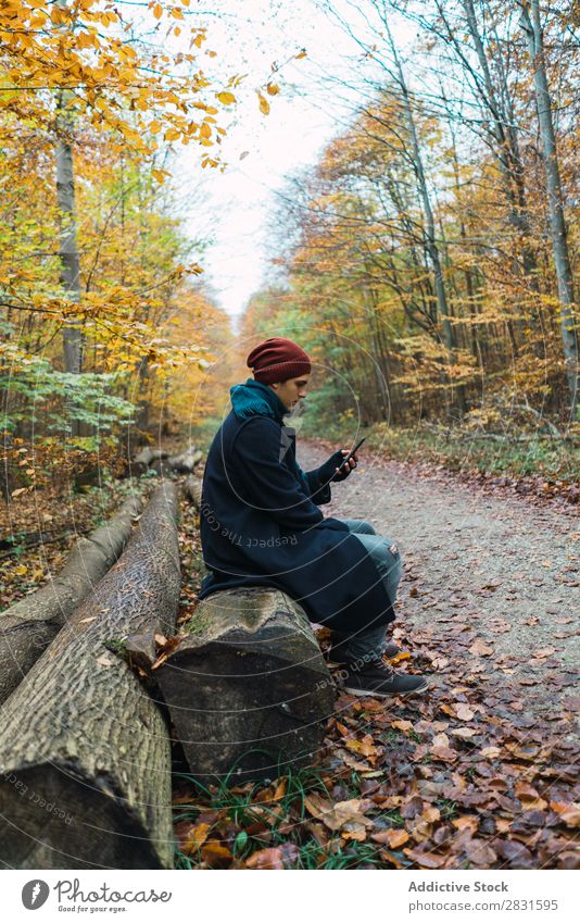 Mann posiert im herbstlichen Wald Straße PDA benutzend Browsen Texten Jugendliche Stadt Lifestyle lässig Mode Stil warme Kleidung Erwachsene modern Mensch