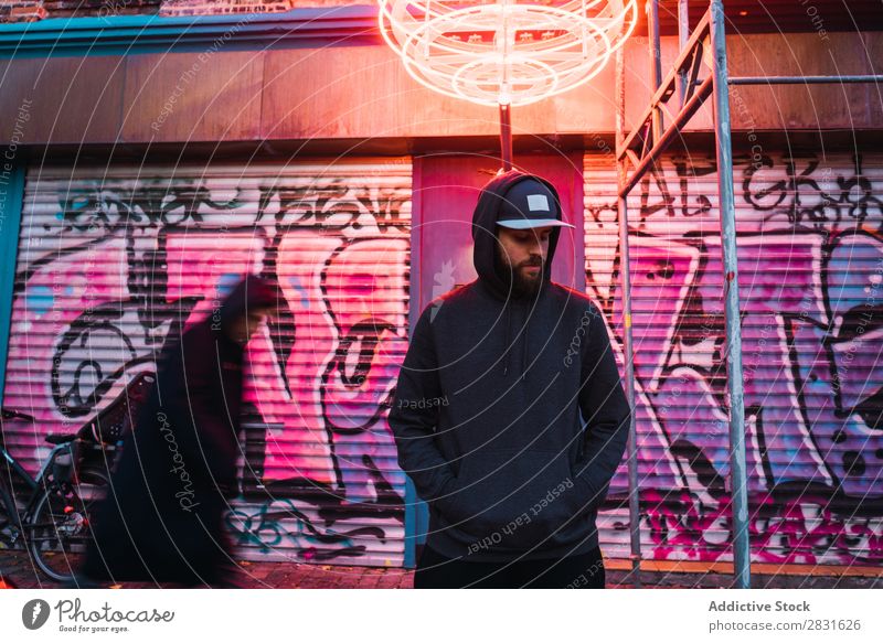 Mann posiert unter dem Neonkreis gutaussehend Großstadt Augen geschlossen neonfarbig stehen Straße Jugendliche Stadt Lifestyle lässig Mode Kreis Stil Erwachsene