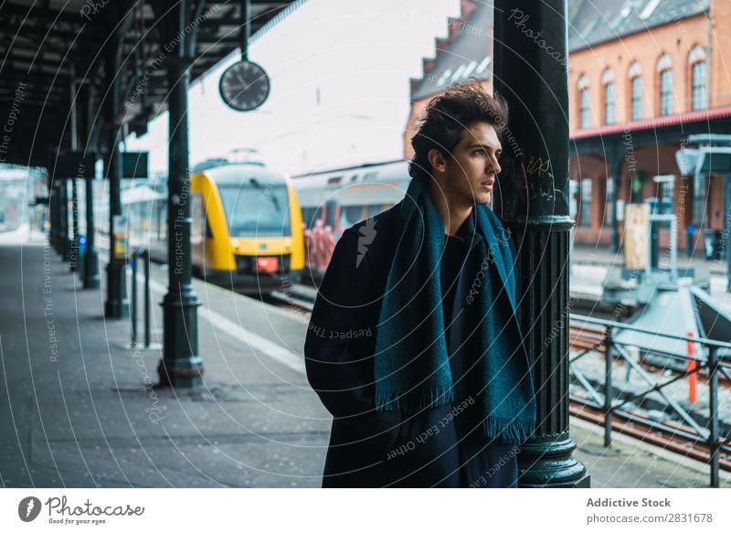 Junger stilvoller Mann auf dem Bahnhof gutaussehend Großstadt Straße Station Eisenbahn Passagier warten Jugendliche Stadt Lifestyle lässig Mode Stil Wegsehen