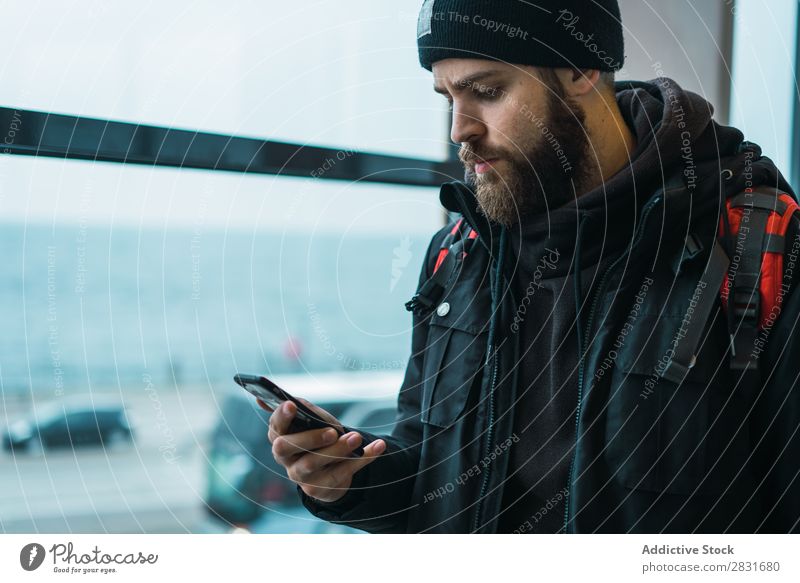 Mann mit Telefon auf der Station gutaussehend Großstadt Tourist Rucksack PDA benutzend beobachten warten Jugendliche Stadt Lifestyle lässig Mode Stil Erwachsene