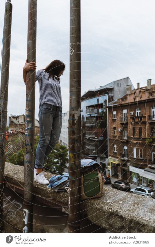 Frau, die auf einem Betonzaun steht. Mensch Stadt Grunge Körperhaltung Zaun Ausdruck Jugendliche modern Stil Straße selbstbewußt Pose stehen Außenaufnahme