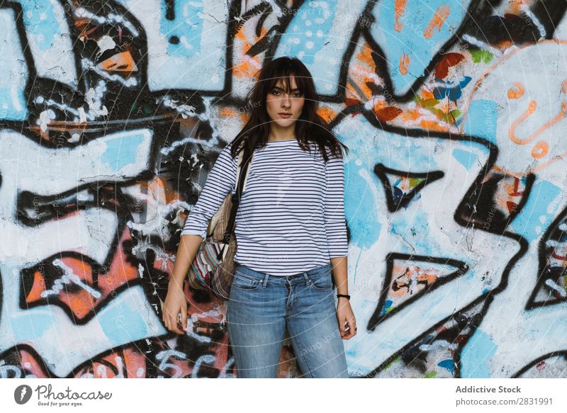 Lässige Frau auf Graffiti-Wandhintergrund Mensch lässig Körperhaltung reisend Stil Stadt Beautyfotografie mehrfarbig Porträt emotionslos Straße modern