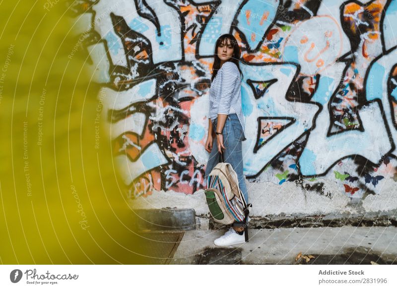 Freizeitmodell an der Straße stehend Mensch lässig Körperhaltung Wand selbstbewußt Stil Stadt Accessoire Rucksack reisend Graffiti Beautyfotografie mehrfarbig