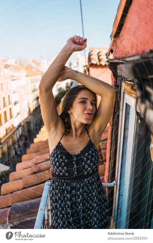 Inhaltsmodell Grimassieren auf dem Balkon Frau heiter romantisch Fröhlichkeit Grimasse Zunge zeigen Skyline Terrasse Körperhaltung Ausdruck Beautyfotografie