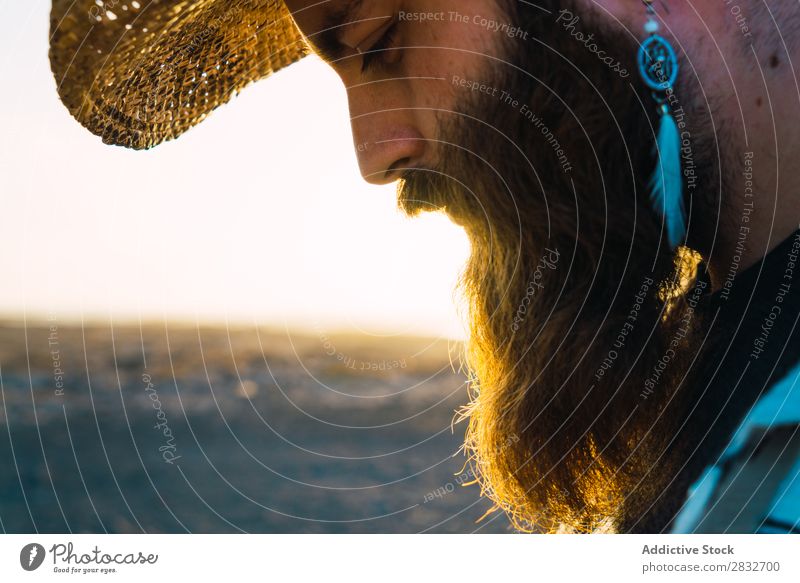 Bartiger Mann mit Hut gegen Sonnenlicht bärtig Cowboy Stil selbstbewußt Natur Porträt Länder maskulin ernst Strohhut Outfit Außenaufnahme Ausdruck Reisender