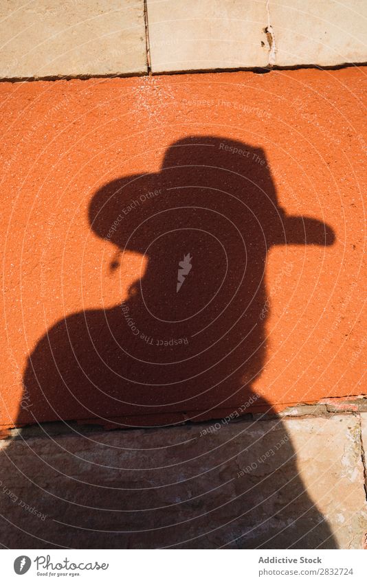 Männlicher Schatten mit Pistole an der Wand Mann Cowboy Westen Silhouette wild Western Umrisslinie Hut hell Risiko Sonnenlicht Kontrast gefährlich Stil
