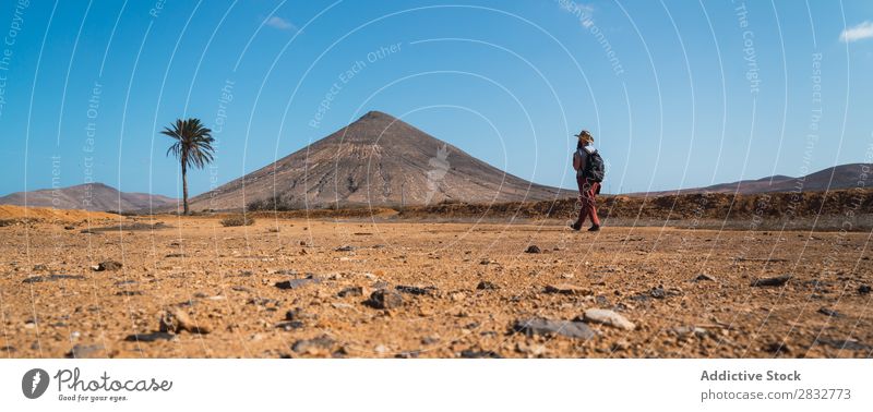 Mann mit Rucksack wandert durch die tropische Wüste Reisender Trekking Freiheit Gelände reisend Jahreszeiten Abenteuer Erkundung Düne laufen Tourismus natürlich