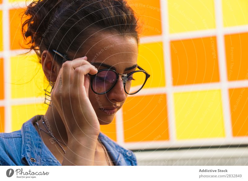 Modell spielt mit einer Brille Frau Körperhaltung spielerisch trendy Straße feminin Ausdruck Accessoire Großstadt Stil Jugendliche Lifestyle lässig Porträt