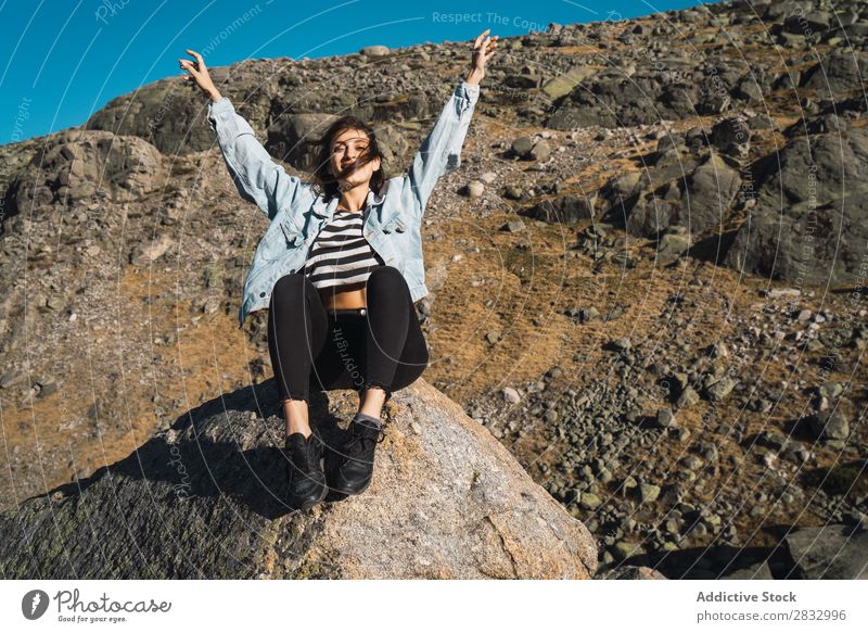 Frau sitzt auf Stein in einem felsigen Hang. Felsen Berghang Natur Sonnenstrahlen schön attraktiv hübsch Jugendliche dünn Ferien & Urlaub & Reisen reizvoll