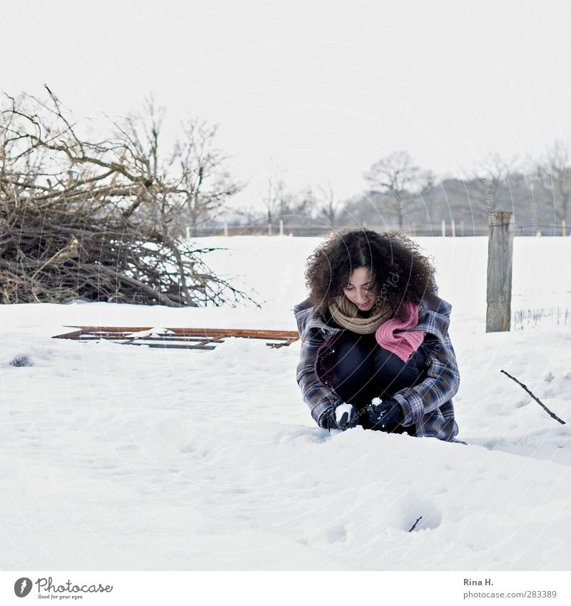 Der erste Schnee 1 Mensch Natur Landschaft Winter Feld Mantel Schal Handschuhe Haare & Frisuren brünett langhaarig Locken hocken Spielen authentisch schön kalt