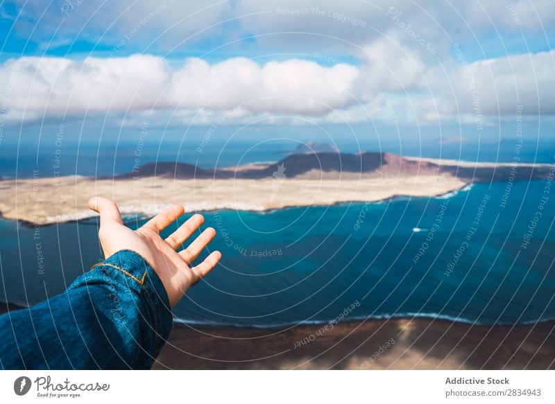 Hand zeigt schöne Meereslandschaft Tourist zeigen Insel Wolken Fluggerät Natur Landschaft natürlich Felsen Stein blau Lanzarote Spanien Aussicht