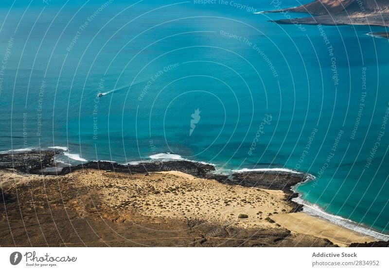 Kleines Boot in blauem Meer Insel Wolken Gefäße klein fliegend Fluggerät Natur Landschaft natürlich Felsen Stein Lanzarote Spanien Aussicht