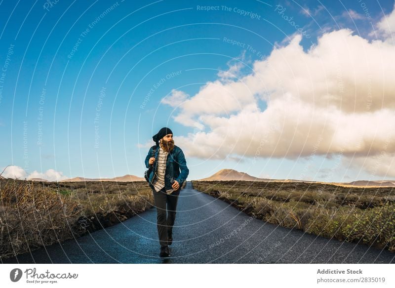 Mann, der auf der Straße im Feld geht. Tourist laufen Berge u. Gebirge regenarm Wolken Natur Landschaft natürlich Felsen Stein Lanzarote Spanien Aussicht