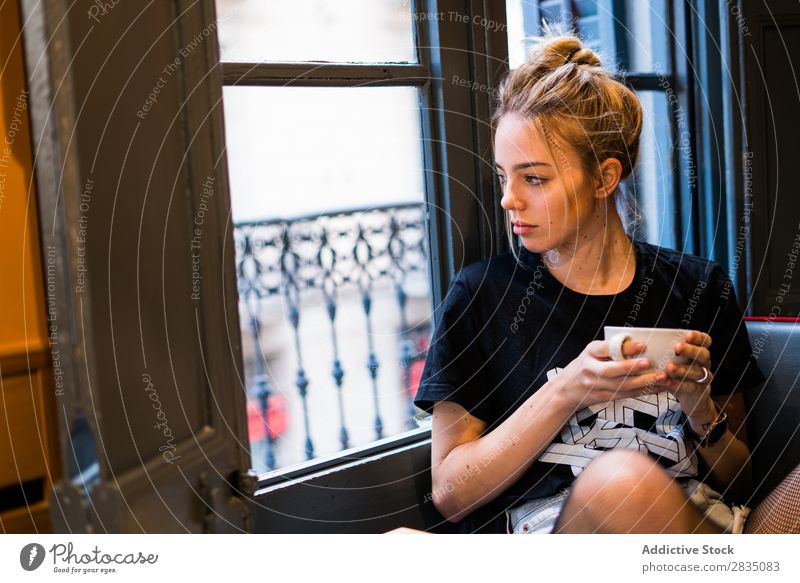 Nachdenkliche Frau mit Tasse, die auf das Fenster schaut. Jugendliche Becher trinken Halt schön Beautyfotografie Porträt Mensch Textfreiraum Kaukasier attraktiv