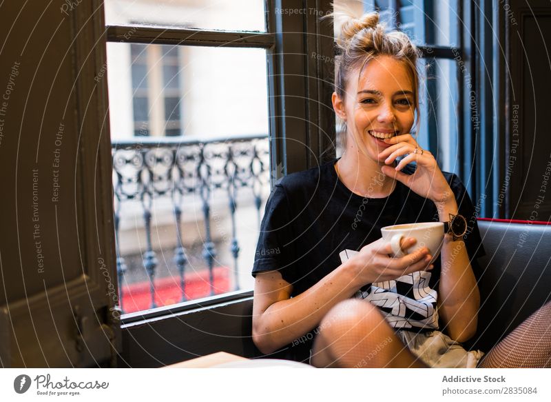 Lachende Frau hält eine Tasse. Jugendliche lachen Becher Blick in die Kamera trinken schön Beautyfotografie Porträt Mensch Textfreiraum Kaukasier attraktiv
