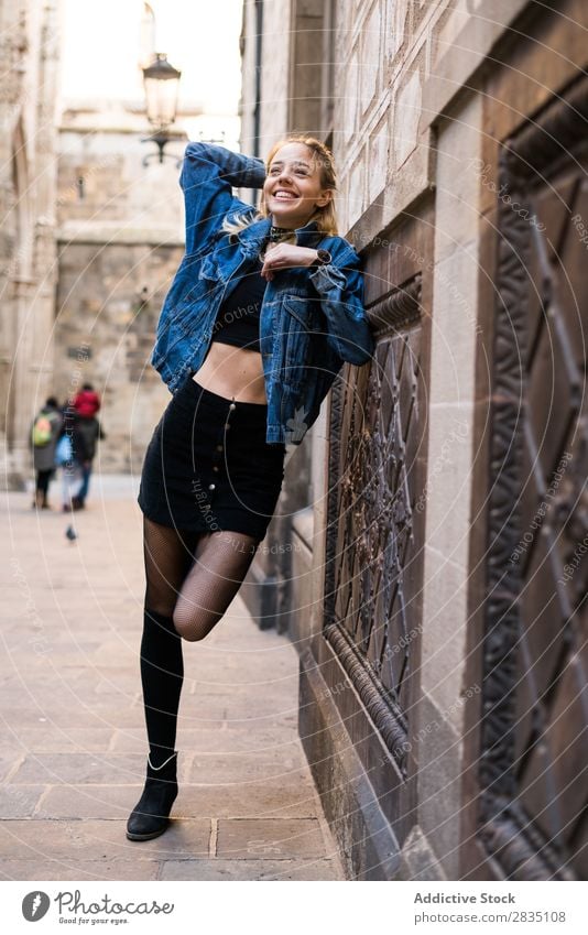 Lachende Frau, die an der Wand posiert. stehen lässig Straße Großstadt Stadt Jugendliche schön Blick in die Kamera Beautyfotografie attraktiv Porträt heiß