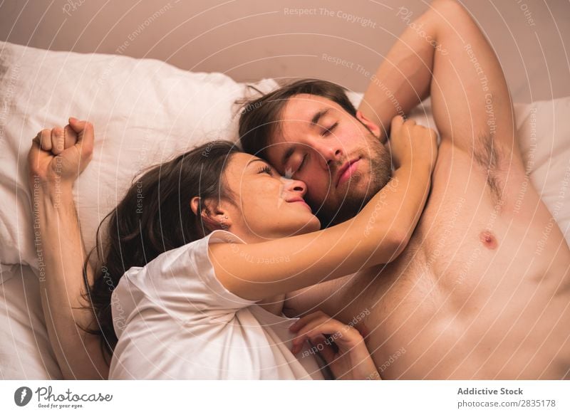 Frau, die auf einen schläfrigen Freund schaut. Paar Umarmen Mann strecken Morgen Liebe Jugendliche Partnerschaft Mensch 2 Bett Schlafzimmer Romantik