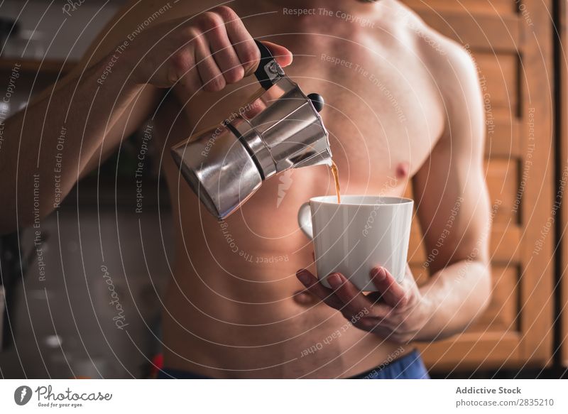 Hemdloser Mann beim Kaffee trinken Mensch Gießen Füllung Tasse Morgen Becher heiß Frühstück Lifestyle heimwärts frisch Koffein Topf eingießen Porträt Küche