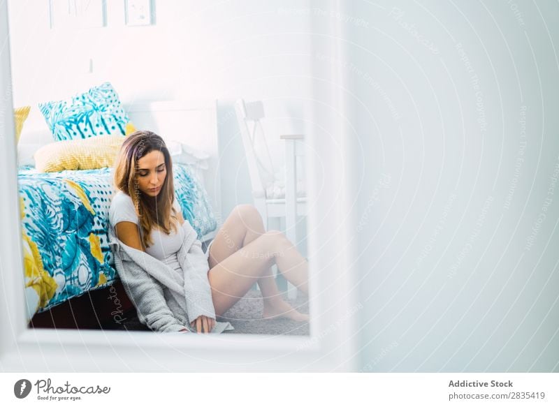 Hübsche Frau liest ein Buch auf dem Boden. hübsch heimwärts Jugendliche Körperhaltung sitzen lesen Bett Roman Literatur Porträt schön Lifestyle Beautyfotografie
