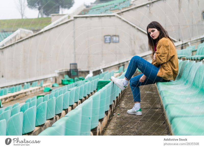 Junges süßes Mädchen in einem verlassenen Stadion Jugendliche Einstellung niedlich schön Verlassen Zuschauerraum kalt Winter Flugzeugsitz Porträt