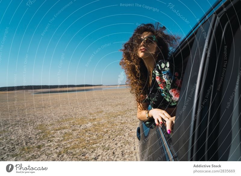 Frau genießt das Autofahren in der Wüste PKW Freiheit Wind Fenster Geschwindigkeit Beautyfotografie Fahrzeug wehendes Haar Verkehr Freude Umwelt
